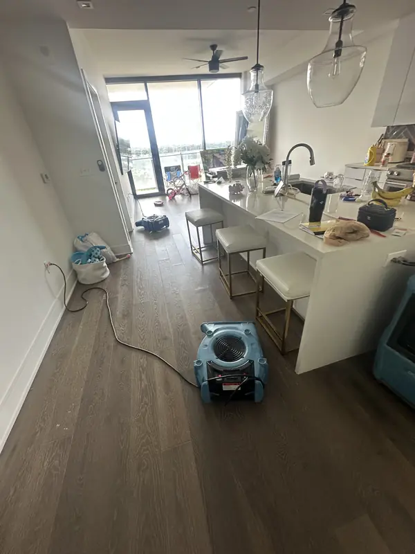 Air movers positioned along the floor of an open kitchen and living space